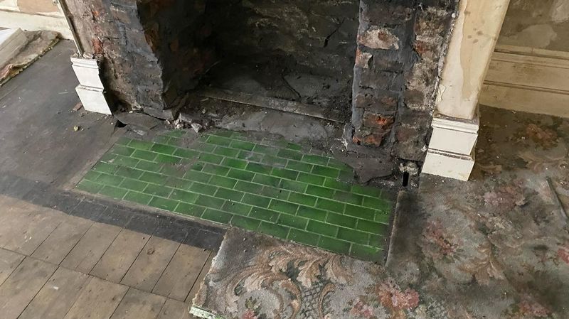 Original green-glazed bricks revealed in fireplace